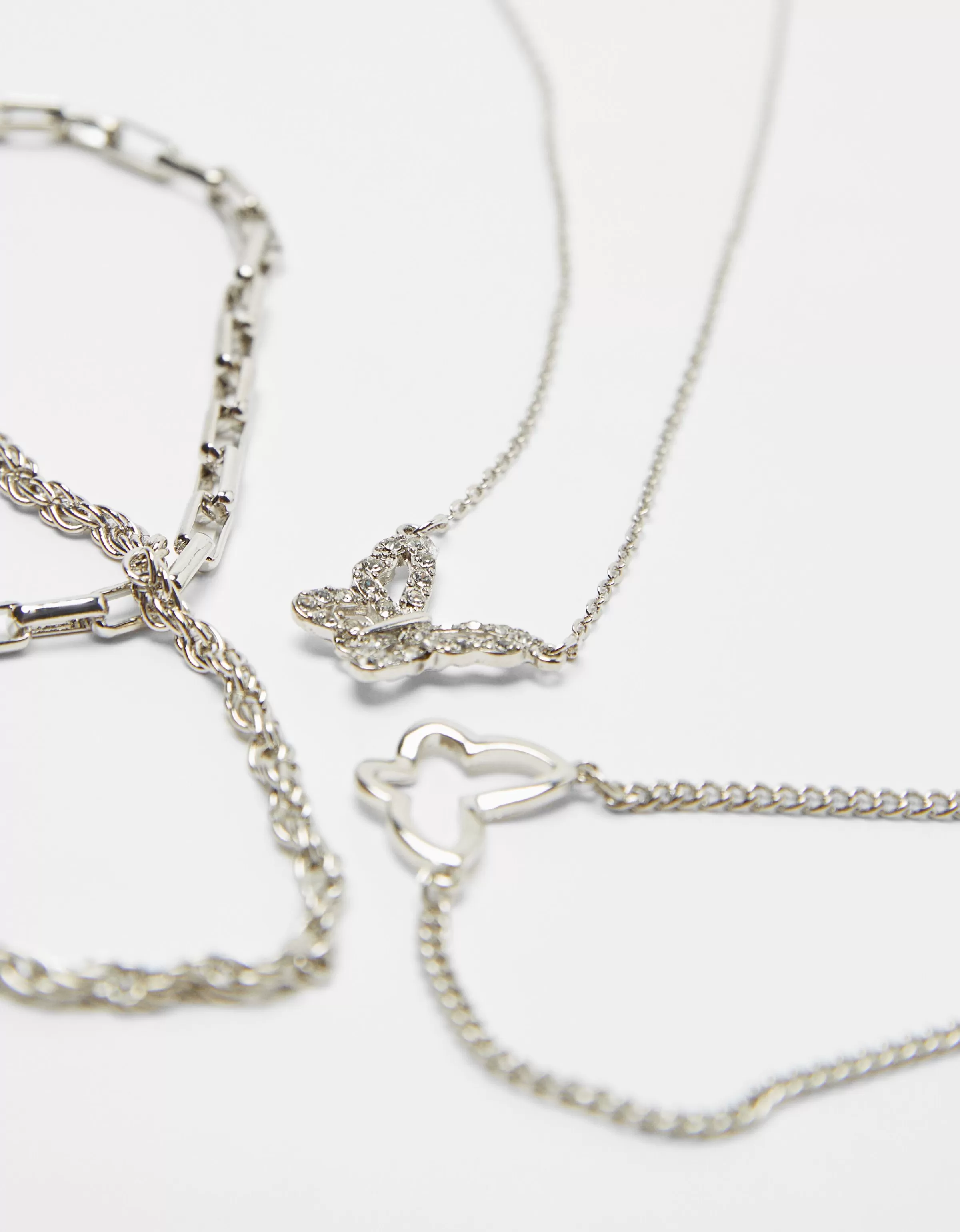 Bershka - Set di 4 collane con dettagli farfalla in argento, perfette per look quotidiani ed eventi speciali